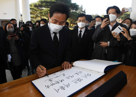 오세훈 제38대 서울특별시장이 8일 서울 동작구 국립서울현충원을 찾아 참배한 뒤 방명록을 작성하고 있다. 오 시장은 방명록에 '다시 뛰는 서울시. 바로 서는 대한민국'이라고 적었다.[사진=연합뉴스]